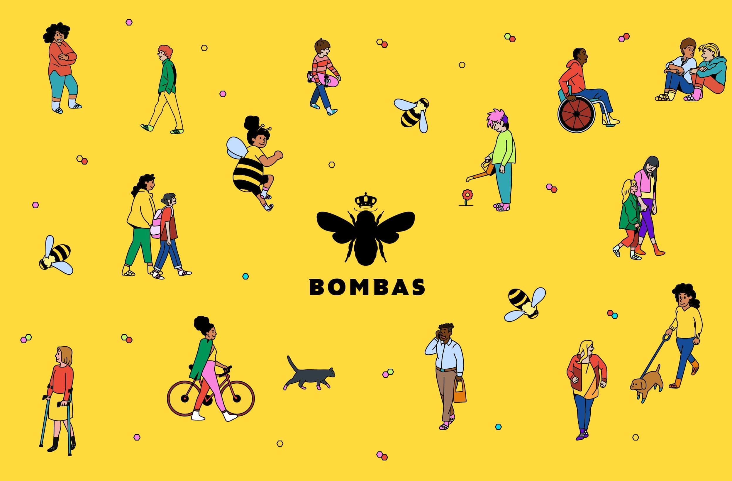 A bright yellow illustrated pattern of diverse people walking, biking, and using mobility aids among cartoon bees and hexagons, centered on the black Bombas bee-and-crown logo above the “BOMBAS” wordmark.